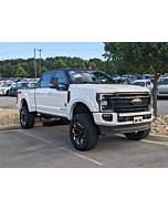 2022 Ford Super Duty F-250 Lariat SCA Black Widow in Star White Metallic with lifted suspension and black accents.