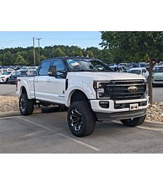 2022 Ford Super Duty F-250 Lariat SCA Black Widow in Star White Metallic with lifted suspension and black accents.