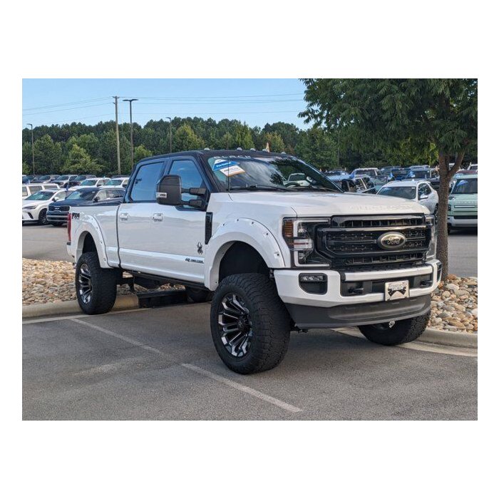 2022 Ford Super Duty F-250 Lariat SCA Black Widow in Star White Metallic with lifted suspension and black accents.